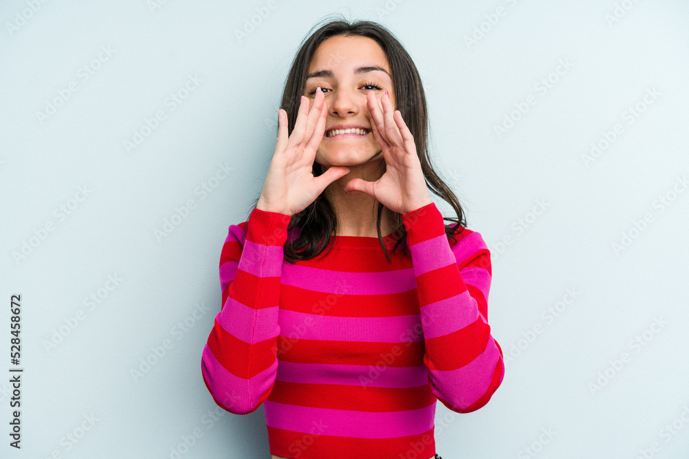 Young caucasian woman isolated on blue background saying a gossip, pointing to side reporting something. Young caucasian woman isolated on blue background saying a gossip, pointing to side reporting something.