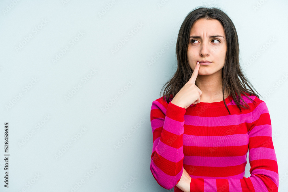 Young caucasian woman isolated on blue background looking sideways with doubtful and skeptical expression. Young caucasian woman isolated on blue background looking sideways with doubtful and skeptical expression.