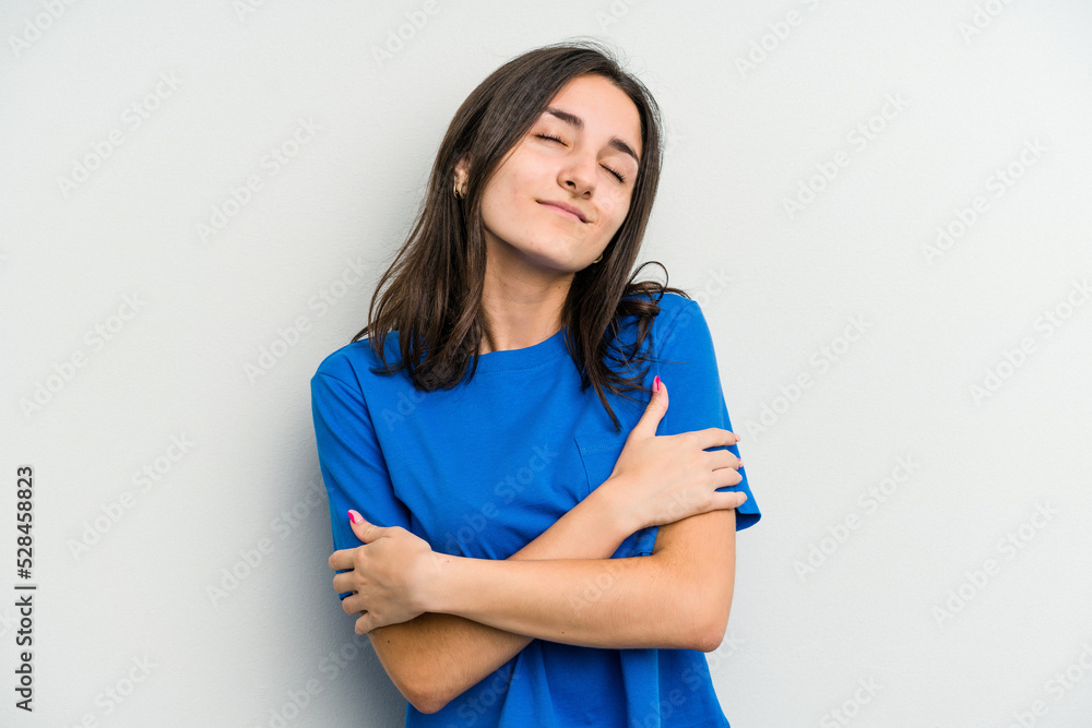 Young caucasian woman isolated on white background hugs, smiling carefree and happy.