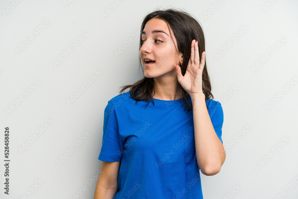 Young caucasian woman isolated on white background trying to listening a gossip. Young caucasian woman isolated on white background trying to listening a gossip.