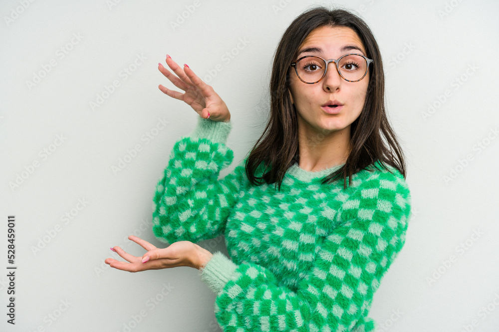 Young caucasian woman isolated on white background shocked and amazed holding a copy space between hands. Young caucasian woman isolated on white background shocked and amazed holding a copy space between hands.