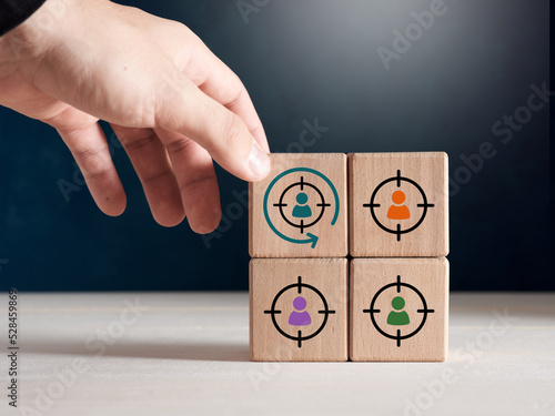 Male hand places wooden cube with retargeting icon. Digital marketing, retargeting, remarketing and website visitor management photo