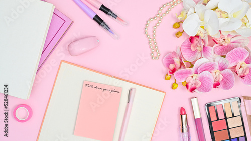 Romantic feminine background with notes, books flowers and make up accessories. Flat lay