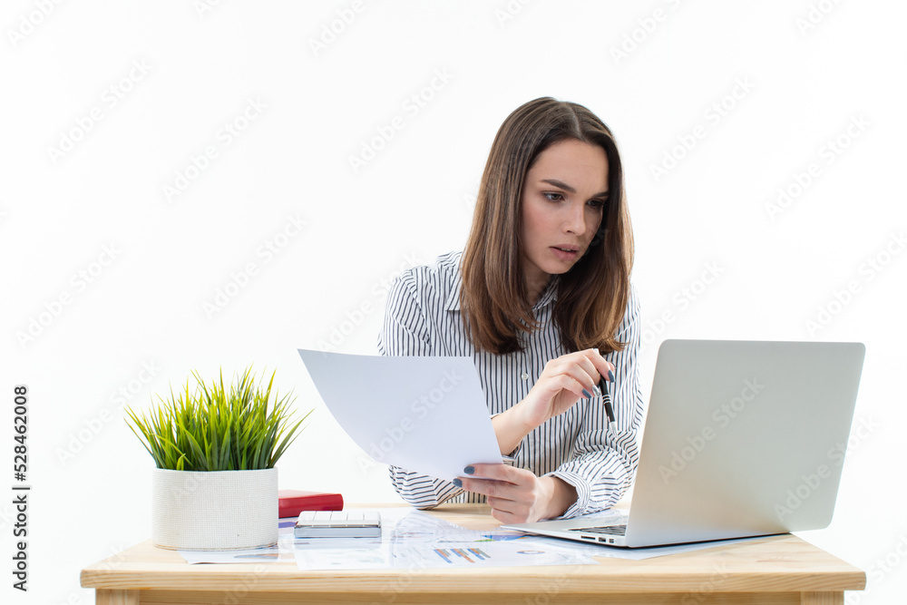 Working process in the office. A young woman secretary examines the documents Working process in the office. A young woman secretary examines the documents