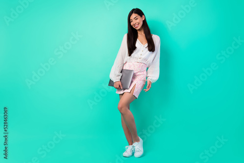 Full length photo of lovely marketer lady boss hold netbook isolated on aquamarine color background