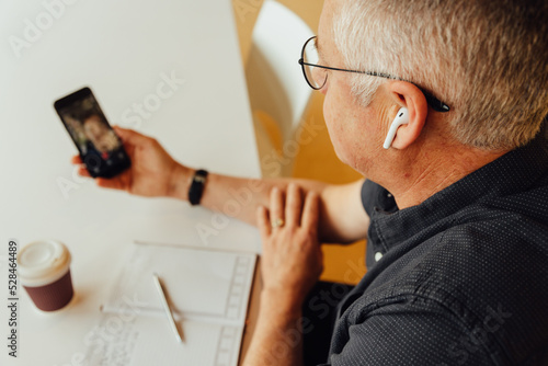 Mature businessman talking on video call in office