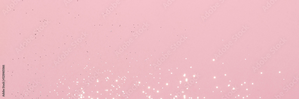 Sparkling silver glitter on pink background banner texture. Abstract holiday blurred lights header. Wide screen wallpaper. Panoramic web banner with copy space for design. Selective focus