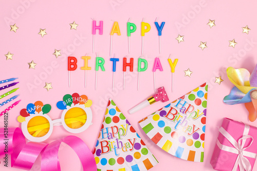 Birthday party background with party accessories on pastel pink theme. Flat lay