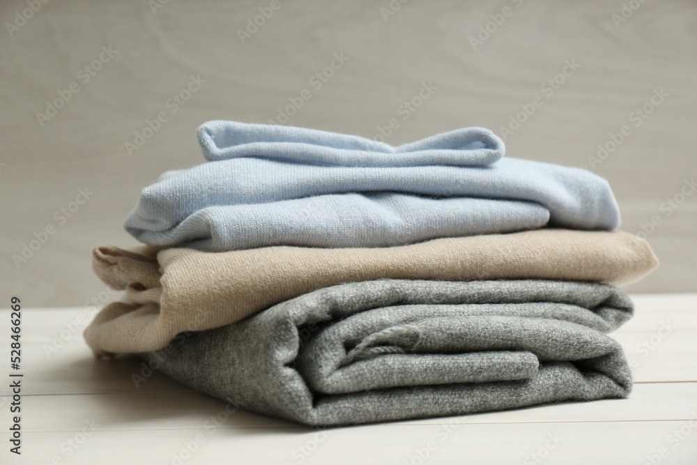 Stack of cashmere clothes on wooden table Stack of cashmere clothes on wooden table