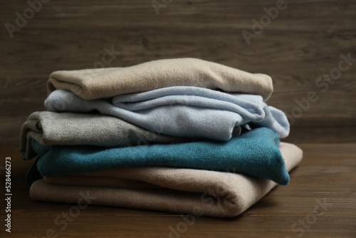 Stack of cashmere clothes on wooden background