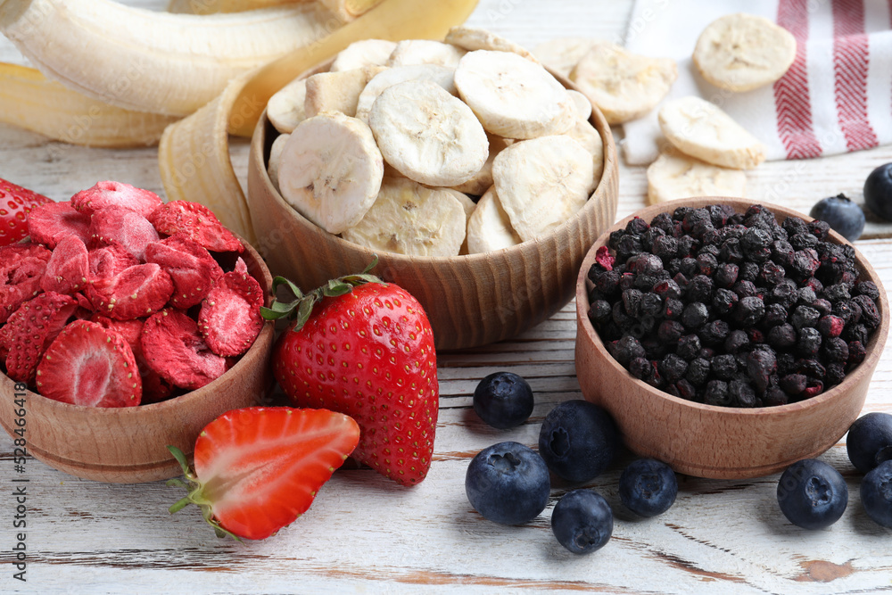 Different freeze dried and fresh fruits on white wooden table, closeup Different freeze dried and fresh fruits on white wooden table, closeup