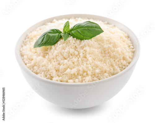 Bowl with grated parmesan cheese and basil isolated on white