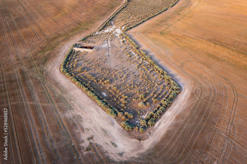 Aerial view of an odd shaped dried waterhole on parched farmland photo