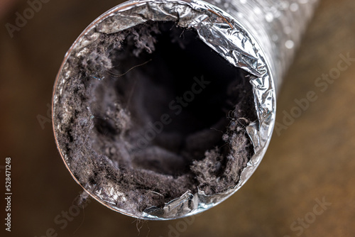 Leinwand Poster A dirty laundry flexible aluminum dryer vent duct ductwork filled with lint, dus