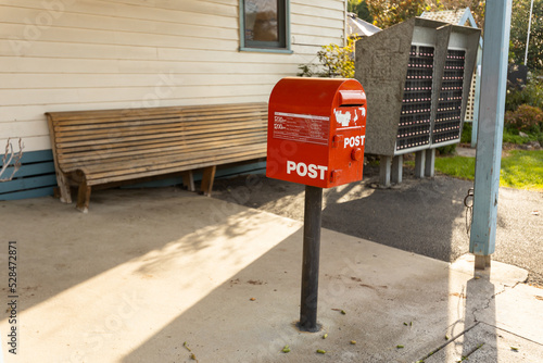 A red australia post letter box stripped of all branding and logos.