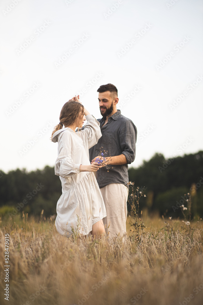Loving couple of man and woman in the field. A couple in love is walking in the field and enjoying life. Romance and love. Happy and romantic couple. Love between two people. Loving couple of man and woman in the field. A couple in love is walking in the field and enjoying life. Romance and love. Happy and romantic couple. Love between two people.