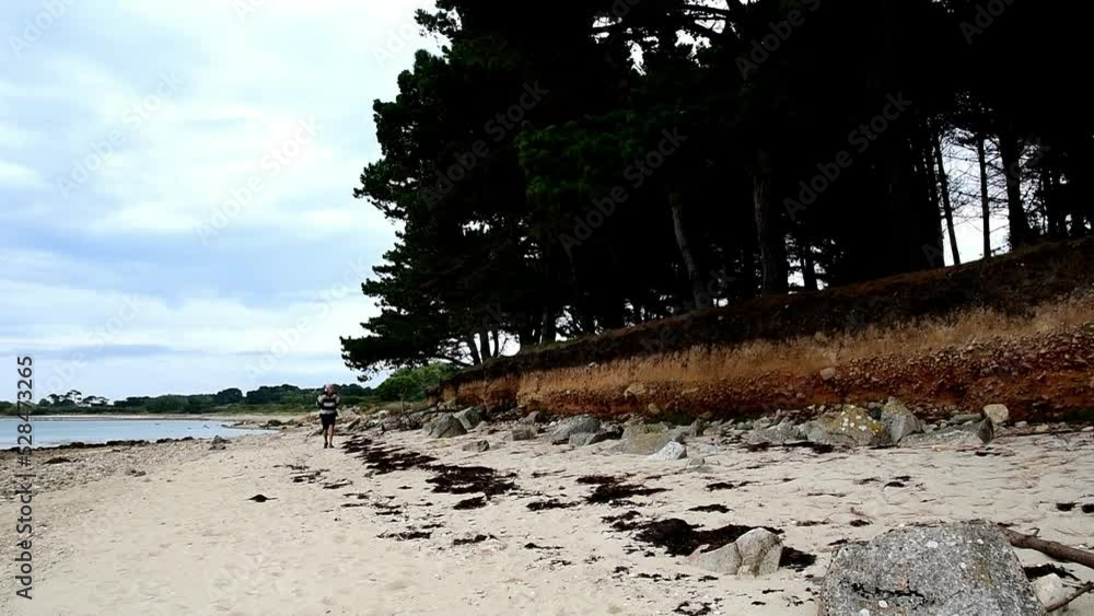 Retired hiker walking along the sea in Brittany - France Retired hiker walking along the sea in Brittany - France