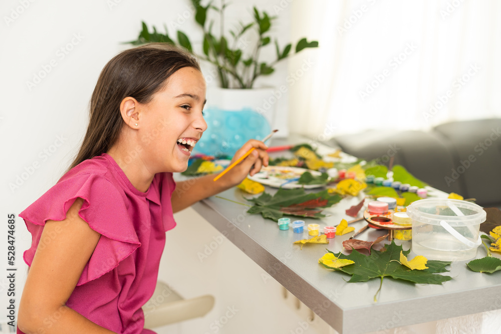 A child paints a picture of an autumn leaf with paints. Children's hands. Favorite hobby, materials for creativity. A child paints a picture of an autumn leaf with paints. Children's hands. Favorite hobby, materials for creativity.