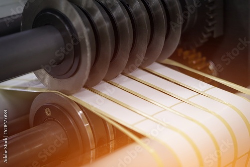 Fotografie Rotating knives for cutting a self-adhesive label into several narrow ribbons