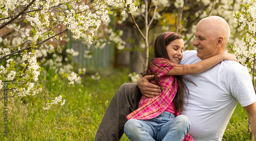 Fototapeta premium Grandfather And granddaughter on flower farm
