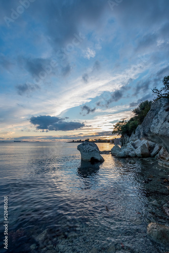 Sunset with rocks, Rock on sea with colorful sunset clouds beautiful background for travel agencies © Aytug Bayer
