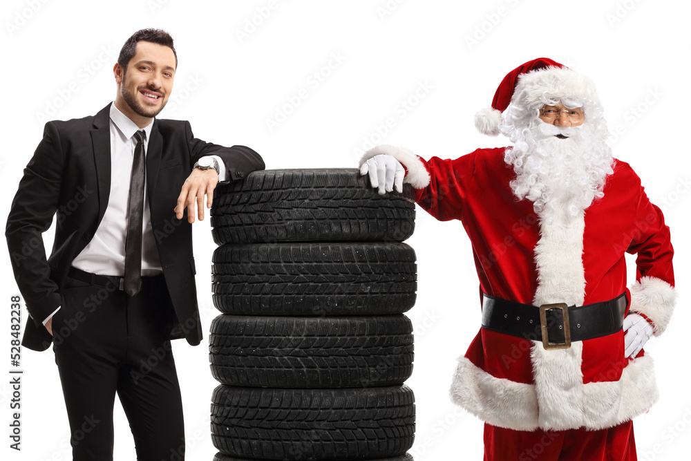 Businessman and Santa Claus leaning on a pile of car tires