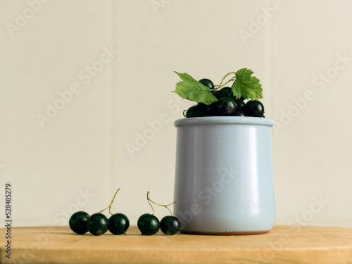 Wallpaper Mural black currant berries in a vase on a wooden table Torontodigital.ca