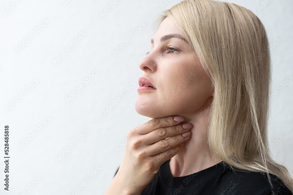Unrecognizable woman holds her throat, sore throat