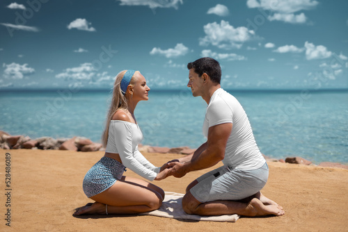 Couple man and woman on the ocean seashore - romantic hugs and sunset at the tropical ocean beach. Happy honeymoon photo.