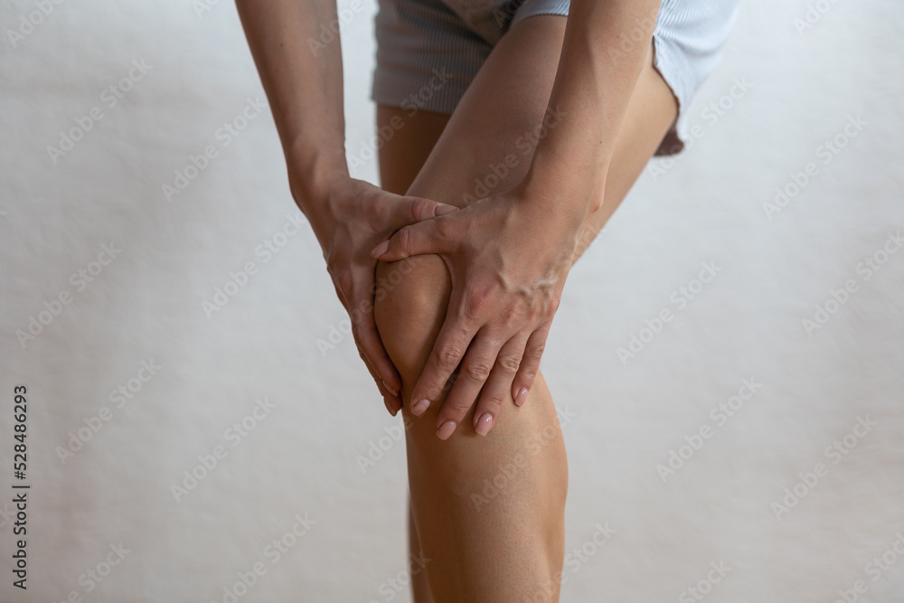 Closeup woman hand hold knee with pain symptom, health care and medical concept Closeup woman hand hold knee with pain symptom, health care and medical concept