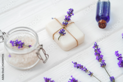 Lavender soap bars and spa products with lavender flowers on a white wooden table