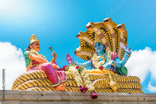 Statue of Lord vishnu and lakshmi Hindu God and goddess in daylight, low angle shot. photo