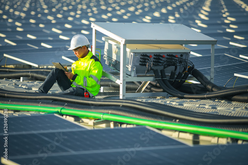 Portrait of professional man engineer working checking the panels at solar energy on buoy floating. Power plant with water, renewable energy source. Eco technology for electric power in industry.
