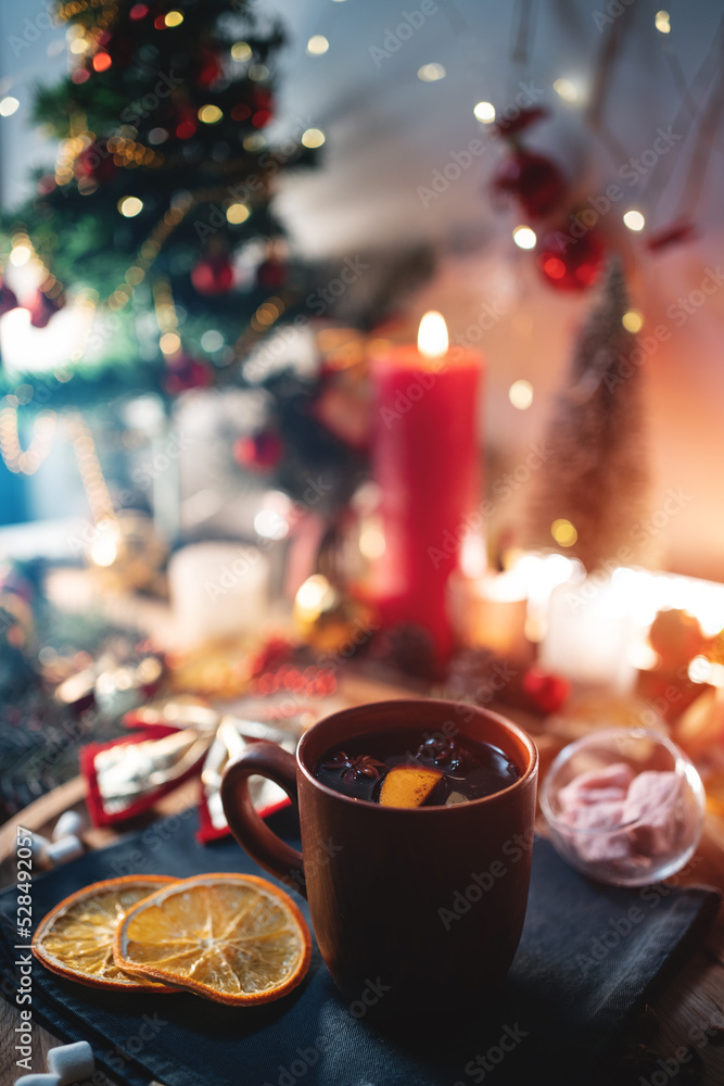 mulled red wine gluhwine in cup with orange, christmas decor table with candles mulled red wine gluhwine in cup with orange, christmas decor table with candles