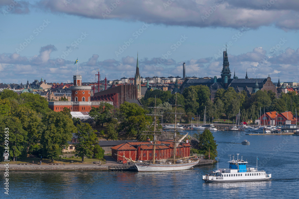 Harbor commuting boat passing the depth Vasa djupet turning to the old town Gamla Stan a sunny autumn day in Stockholm