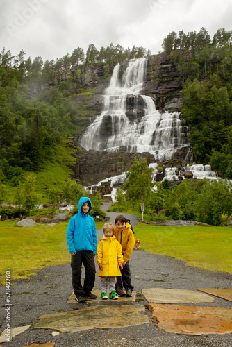 People, visiting Tvinnefossen waterfall, children enjoying the amazing views in Norway to fjords, mountains and other beautiful nature
