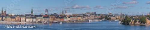 Panorama view over the bay Saltsjön, the old town Gamla Stan, commuting boats, a harbor ferry and a steam commuting boat leaving for the archipelago a sunny autumn day in Stockholm
