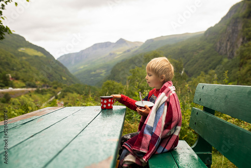 People, children enjoying the amazing views in Norway to fjords, mountains and beautiful nature miracles, having breakfast while wild camping