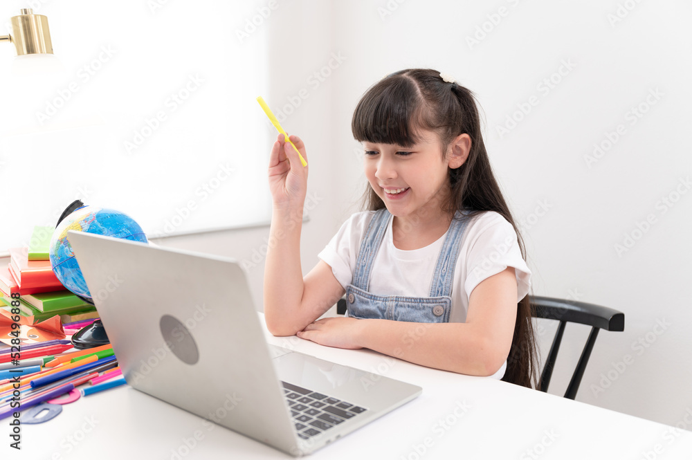 Portrait kids girl doing homework with notebook computer at home Portrait kids girl doing homework with notebook computer at home