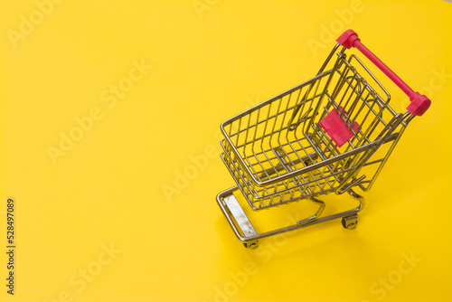 Fast shopping cart on yellow background with copy space for text