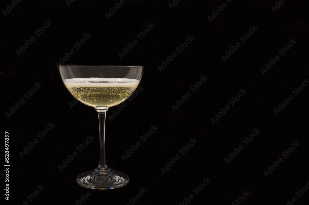 Sparkling wine Martini Asti in a glass on a black background Sparkling wine Martini Asti in a glass on a black background