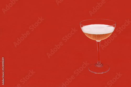 Sparkling wine Martini Asti in a glass on a red background
