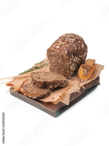 sliced ​​loaf of black rye bread with sunflower seeds on a white background isolated