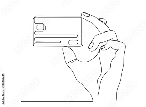 Continuous one line drawing of hand holding credit card. 