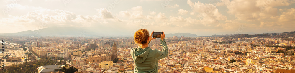 Woman taking photo of city panoramic view (malaga in Spain)