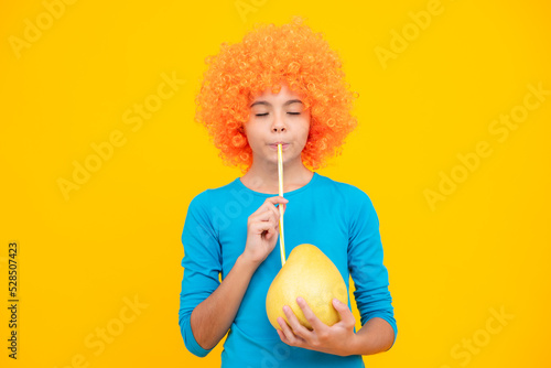 Funny teenage girl hold citrus fruit pummelo or pomelo  big green grapefruit isolated on yellow background.