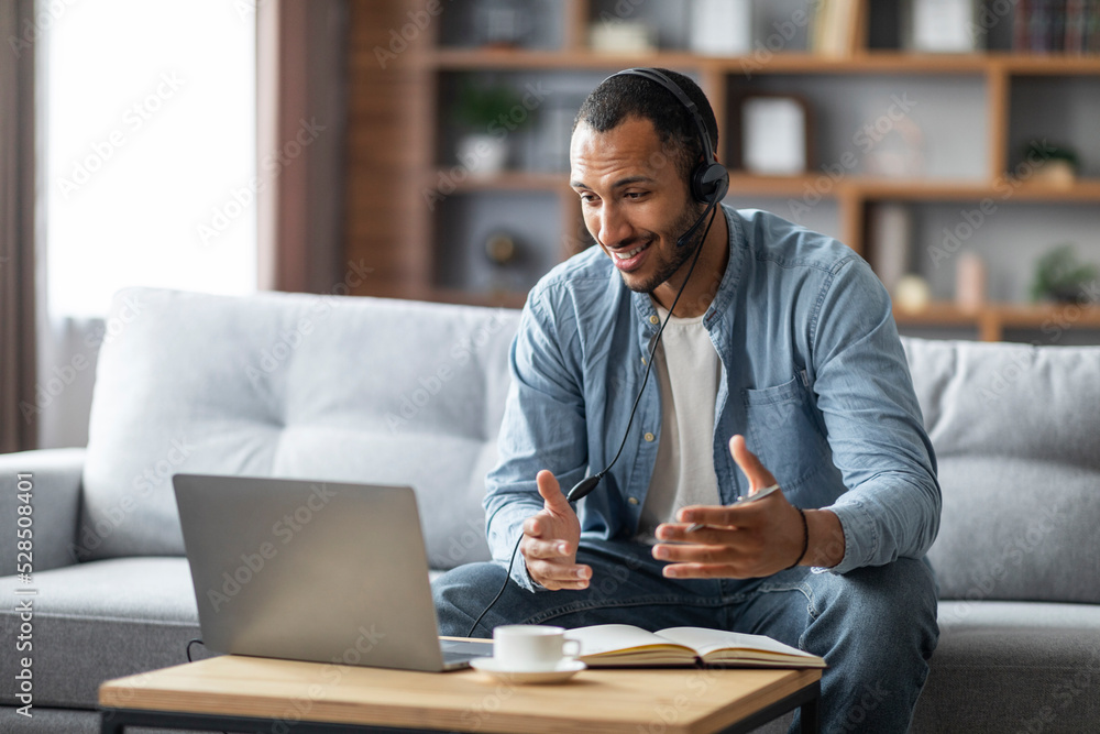 Distance Communication. Smiling Black Guy In Headset Having Web Conference On Laptop Distance Communication. Smiling Black Guy In Headset Having Web Conference On Laptop