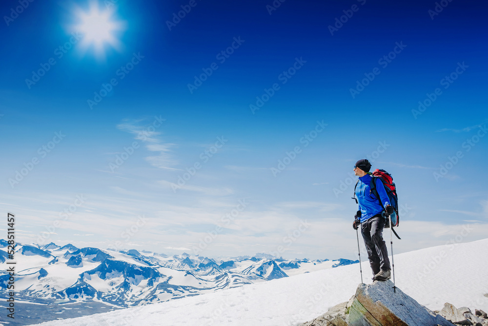 Hiker with backpack standing on top of a mountain and enjoying tne view Hiker with backpack standing on top of a mountain and enjoying tne view