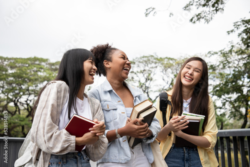 Diversity of happy woman student holding books and looking at natural outdoors at park. Prepare for college and university concept. Informal education and natural research