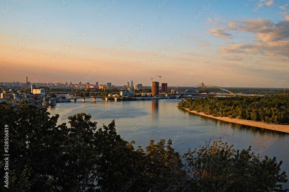 Kyiv, Ukraine-September 04, 2022:Aerial landscape view of ancient Podil neighborhood. River Dnipro with several bridges at the background. Autumn sunset colors
